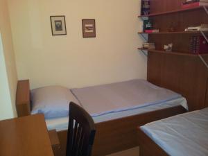 Cette petite chambre comprend deux lits et une table. dans l'établissement Apartment City-Center, à Vienne