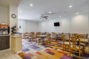 Econo Lodge Darien في دارين: غرفة طعام مع طاولات وكراسي وتلفزيون