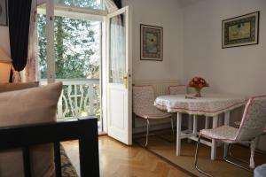 Habitación con mesa, sillas y balcón. en Vila Ana Generoes Bled, en Bled