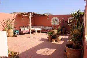 a patio with a couch and a table and potted plants at Tilily Apartment in Mirleft