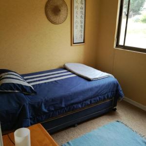 Cama pequeña en habitación con ventana en Depto. Vistamar Oriente, en Papudo