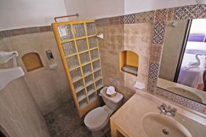a bathroom with a toilet and a sink and a mirror at Hotel Mary Carmen in Cozumel