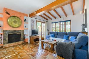 a living room with a blue couch and a fireplace at Villa Can Giovanni in Sant Jordi