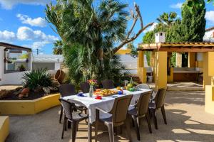 a table and chairs on a patio with palm trees at Villa Can Giovanni in Sant Jordi