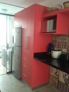 cocina roja con nevera y microondas en Mi casa es su casa, en Lima