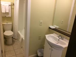 a bathroom with a sink and a toilet and a mirror at Nice Inn Edmonton in Edmonton