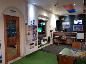 a man sitting at a counter in a store at Adelaide Travellers Inn Backpackers Hostel in Adelaide