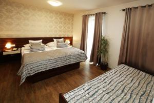 a hotel room with two beds and a window at Apartmán Livingstone - Roudna in Pilsen