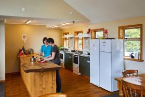two women standing in a kitchen with a counter at Aoraki Mount Cook Alpine Lodge in Mount Cook Village