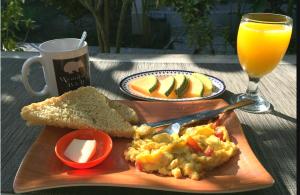 a table with a plate of food and a glass of orange juice at Wombat's B&B in Gili Trawangan