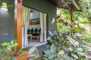 Aura Villa & Spa Amed Bali في آميد: غرفة بجدران خضراء ونباتات