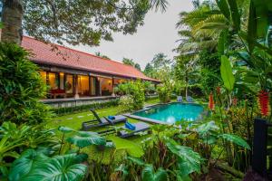 a villa with a swimming pool in a garden at Luxury 3BR Infinity Jungle View Aashaya Villa Ubud in Ubud