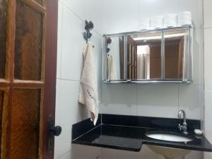 een badkamer met een wastafel en een spiegel bij Centro, Maracanã, rodoviaria perto, SmarTV, vista fantástica in Rio de Janeiro +23 foto's