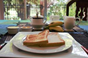 a plate with two slices of bread on a table at Colombo Airport Homestay in Gampaha