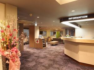 Kurashiki Station Hotel في كوراشيكي: لوبي مكتب مع مكتب استقبال وزهور