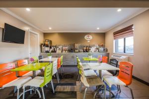 a restaurant with tables and chairs and a kitchen at Super 8 by Wyndham Vacaville in Vacaville