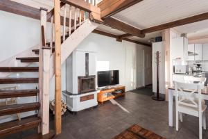 a living room with a staircase and a television at Pyry ja Tuisku Cottages in Muurame