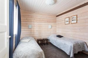 A bed or beds in a room at Pyry ja Tuisku Cottages