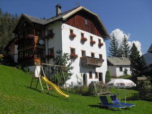 una casa con un tobogán y un parque infantil delante de él en Lüch dl Chessl - Kesslhof, en San Martino in Badia