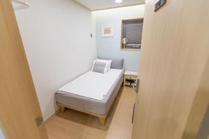 済州市にあるゲスト ハウス ブリックのベッドと窓のある小さな寝室