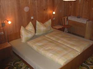 Una cama con almohadas en una habitación. en Lüch dl Chessl - Kesslhof, en San Martino in Badia
