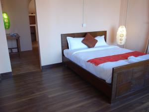 ein Schlafzimmer mit einem großen Bett und Holzboden in der Unterkunft Bodhi Apartment hotel in Baudhatinchule