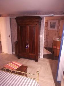 1 dormitorio con armario de madera y cama en Maisonnette de Villiers en Saint-Fargeau-Ponthierry