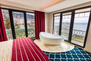 a bathroom with a large tub in a room with windows at Sinema Hotel Ordu in Ordu