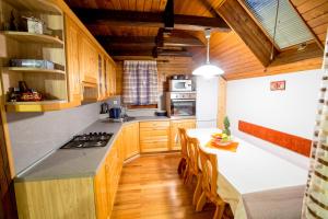 a kitchen with wooden cabinets and a table with chairs at Rogla Chalet Urska in Resnik