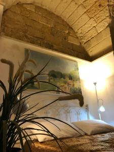 レッチェにあるB&B Corte Dei Muscoのベッドルーム1室(壁に絵画が描かれたベッド1台付)