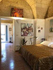 1 dormitorio con 1 cama y una pintura en la pared en B&B Corte Dei Musco, en Lecce