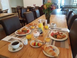 a table with plates of food and cups of coffee at Hoogeind Manor in Somerset West