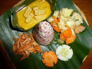 une assiette de nourriture sur une feuille de bananes dans l'établissement Sananda Bungalow, à Lovina