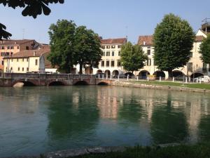 a bridge over a river in a city with buildings at Holiday Treviso Suite LOMBARDI in Treviso
