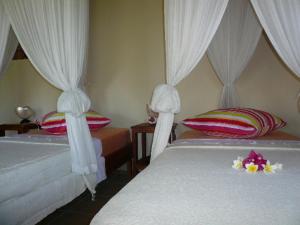 A bed or beds in a room at Sananda Bungalow