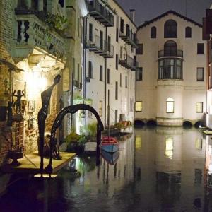 a flooded street with a boat in the water at Holiday Treviso Suite LOMBARDI in Treviso