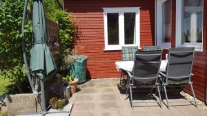 un patio con mesa, sillas y sombrilla en Ferienhaus Weiser, en Cuxhaven