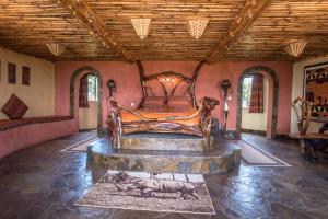 1 dormitorio con cama de madera en una habitación en Rhino Watch Safarilodge en Mweiga