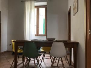 une table à manger avec des chaises vertes et jaunes dans l'établissement Fisherman House - Sorrento Coast, à Sorrente