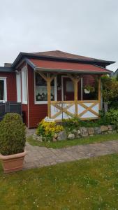 una casa roja con un porche con una valla en Ferienhaus Weiser, en Cuxhaven