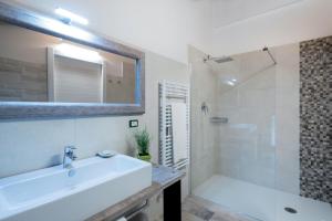 a white bathroom with a sink and a shower at Agriturismo Camisi qh in Cambiago