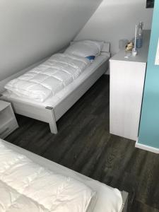 1 Schlafzimmer mit 2 Betten und weißer Bettwäsche in der Unterkunft Haus "Kliffruhe" in Glowe