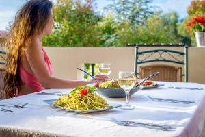 een vrouw aan een tafel met een bord pasta bij Ionian Villas in Ayios Nikitas