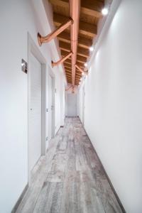a corridor of an empty room with white walls and wooden ceilings at Agriturismo Camisi qh in Cambiago