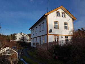 een groot wit huis bovenop een heuvel bij Ferieleilighet på Tromøy, Arendal in Arendal