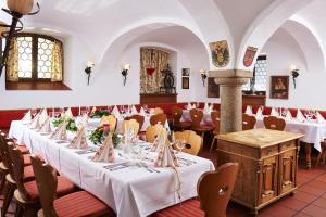 une rangée de tables dans un restaurant avec des nappes blanches dans l'établissement Hotel Gäubodenhof, à Straubing