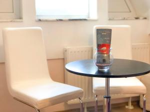a glass vase sitting on a table next to two chairs at Smještaj Natalija in Osijek