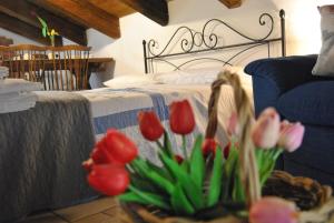 コンヴェルサーノにあるMansarda romantica "Il nido delle rondini"のベッドルーム1室(赤とピンクのチューリップのベッド1台付)