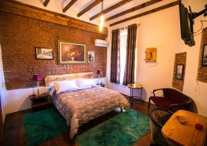 una camera da letto con un letto e un muro di mattoni di Hotel Vila 1928 a Tirana