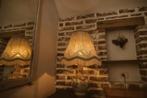 una lámpara sentada en una mesa junto a una pared de ladrillo en Casa Tirol Blaj en Blaj